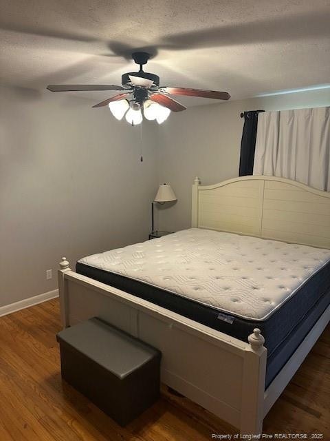 bedroom with wood finished floors, ceiling fan, and baseboards