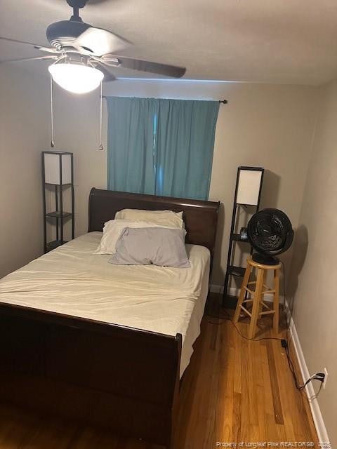 bedroom with wood finished floors, a ceiling fan, and baseboards