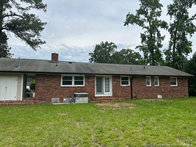 505 W 30th St, Lumberton, NC 28358 - rear view of property featuring brick siding, a chimney, a lawn, and crawl space