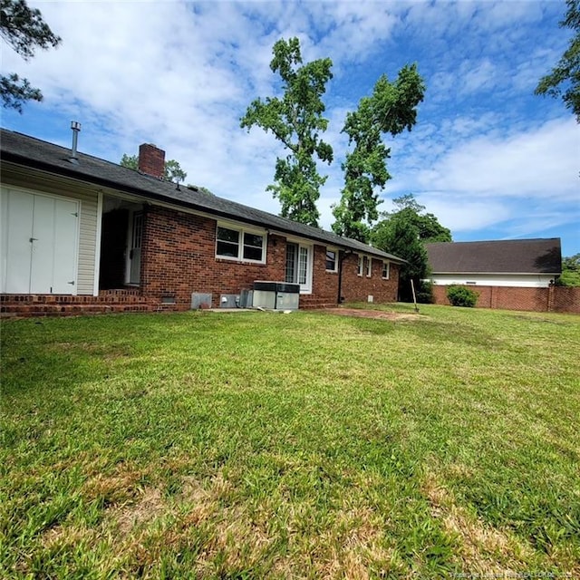 505 W 30th St, Lumberton, NC 28358 - back of property with a chimney, brick siding, a yard, and entry steps