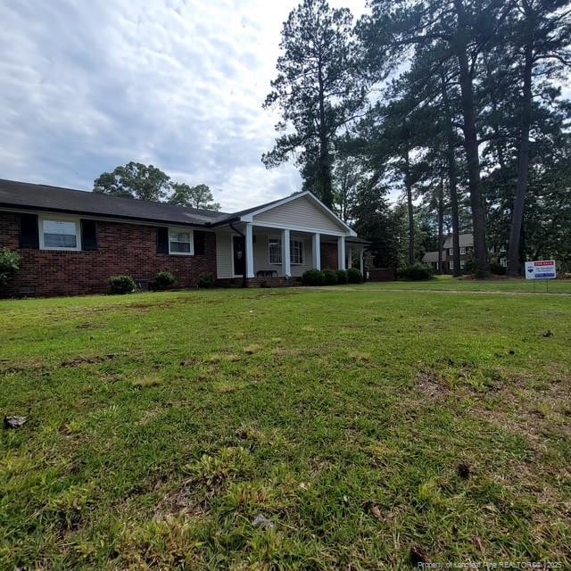 505 W 30th St, Lumberton, NC 28358 - view of front of home with a porch, a front yard, and brick siding