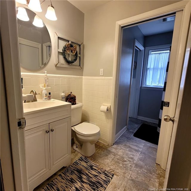 505 W 30th St, Lumberton, NC 28358 - bathroom featuring toilet, vanity, wainscoting, and tile walls