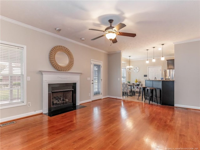 2815 Prioress Dr, Fayetteville, NC 28306 - living area with ornamental molding, ceiling fan, a fireplace with flush hearth, wood finished floors, and a chandelier