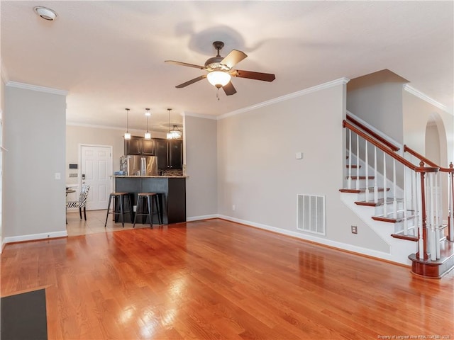 2815 Prioress Dr, Fayetteville, NC 28306 - unfurnished living room with ceiling fan, light wood-style floors, stairs, baseboards, and crown molding