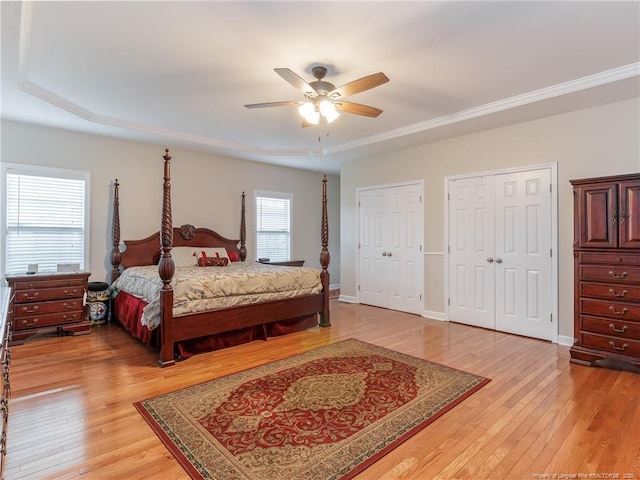 2815 Prioress Dr, Fayetteville, NC 28306 - bedroom with light wood-style floors, two closets, a raised ceiling, and a ceiling fan