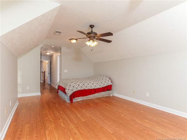 2815 Prioress Dr, Fayetteville, NC 28306 - bedroom with light wood-style floors, lofted ceiling, a textured ceiling, baseboards, and ceiling fan