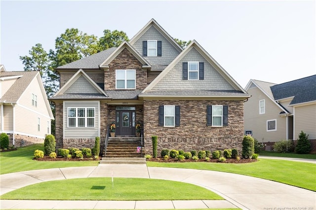 craftsman inspired home with stone siding, a front yard, and roof with shingles