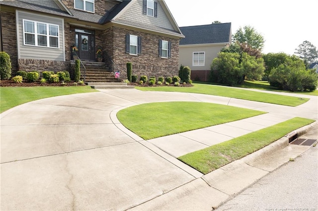 craftsman-style house with stone siding and a front lawn