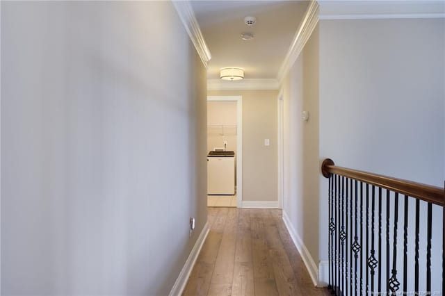hallway with hardwood / wood-style flooring, crown molding, and baseboards
