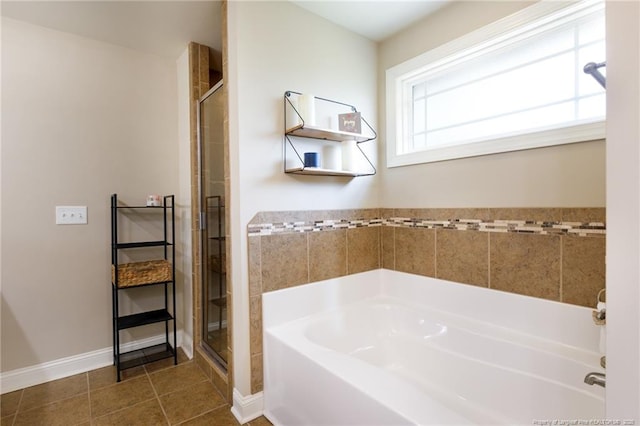 bathroom featuring a shower stall, a bath, tile patterned floors, and baseboards