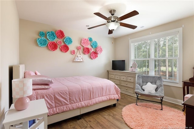 bedroom with wood finished floors, baseboards, and a ceiling fan