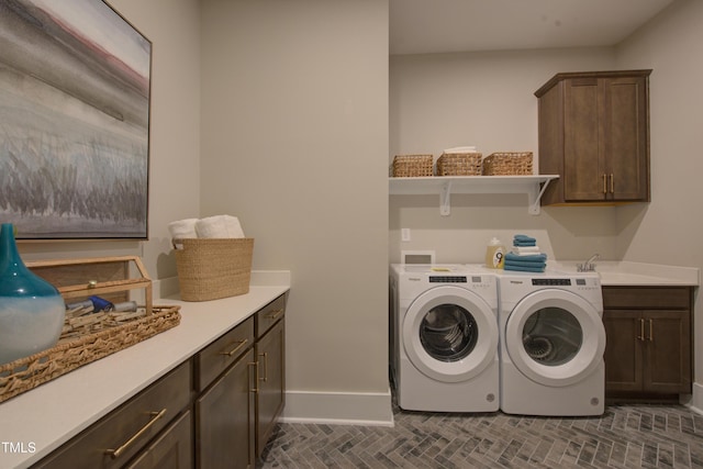 washroom featuring cabinet space, washing machine and clothes dryer, and baseboards