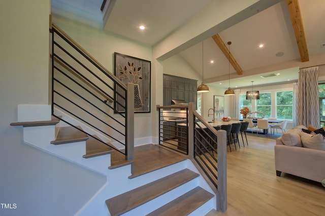 stairway featuring beamed ceiling, wood finished floors, high vaulted ceiling, and recessed lighting