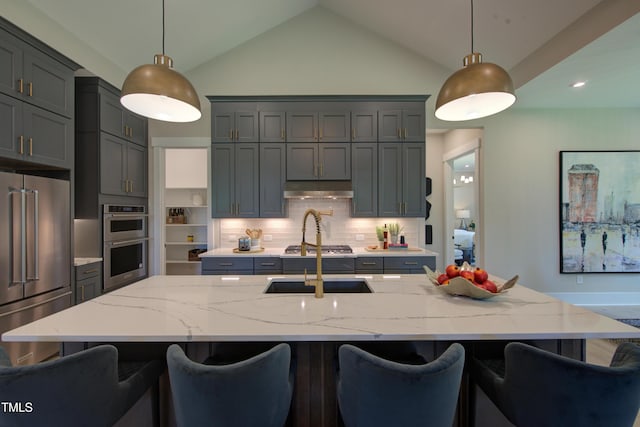 kitchen with stainless steel appliances, light stone countertops, backsplash, lofted ceiling, and hanging light fixtures
