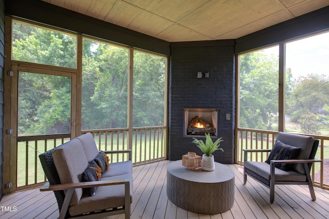 sunroom featuring an outdoor living space with a fireplace