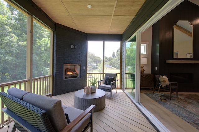 sunroom featuring a brick fireplace