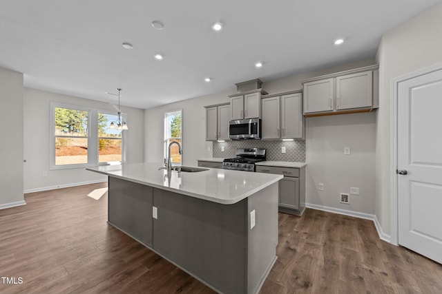 35 Windflower Ct Unit 9, Clayton, NC 27520 - kitchen featuring gray cabinets, stainless steel appliances, a kitchen island with sink, decorative backsplash, and dark wood finished floors
