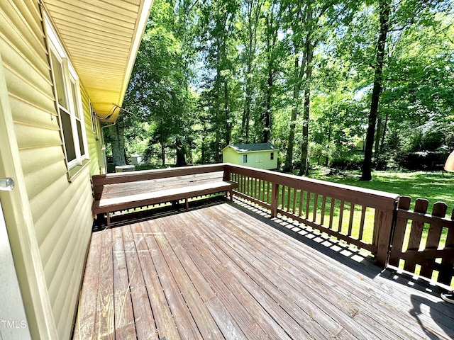 174 Carolina Dr, Reidsville, NC 27320 - wooden terrace with view of wooded area, an outdoor structure, a storage unit, and a yard