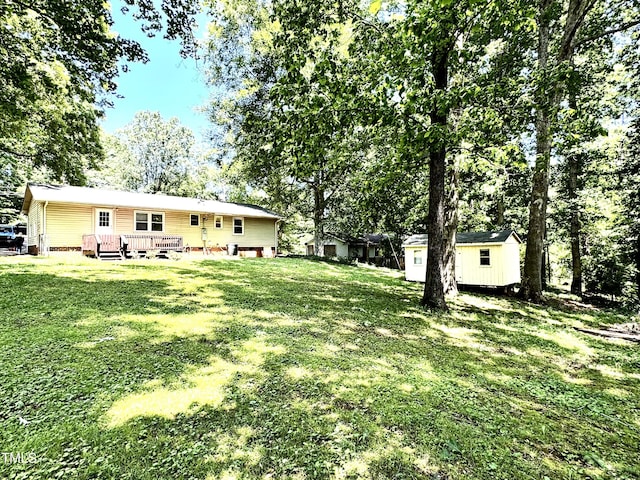 174 Carolina Dr, Reidsville, NC 27320 - view of green lawn with a storage shed, an outbuilding, and a wooden deck