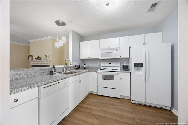 kitchen with white appliances, a sink, white cabinets, ornamental molding, and a textured ceiling