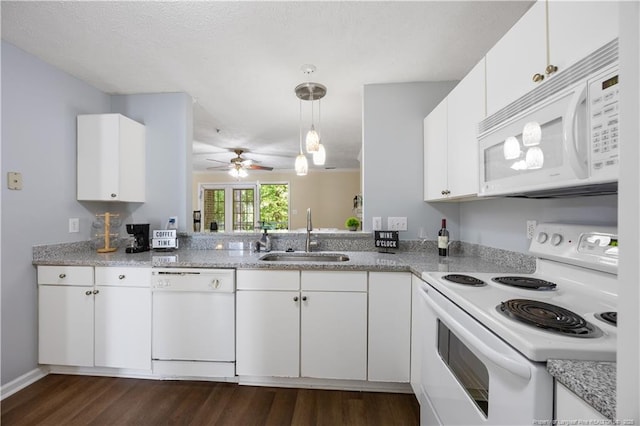 kitchen with white appliances, a sink, dark wood finished floors, ceiling fan, and white cabinetry