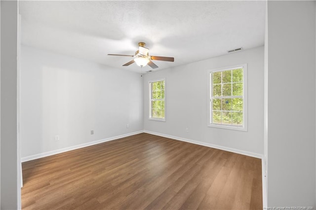 empty room with a ceiling fan, baseboards, and wood finished floors