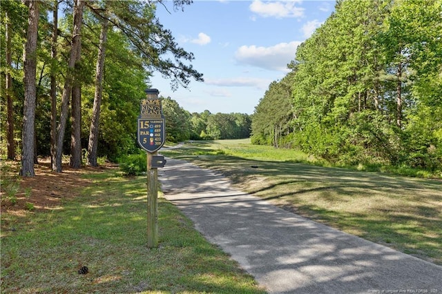 surrounding community featuring a forest view and a lawn