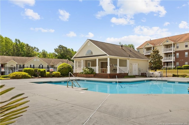 community pool with fence and a patio area