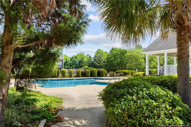 community pool featuring fence and a patio
