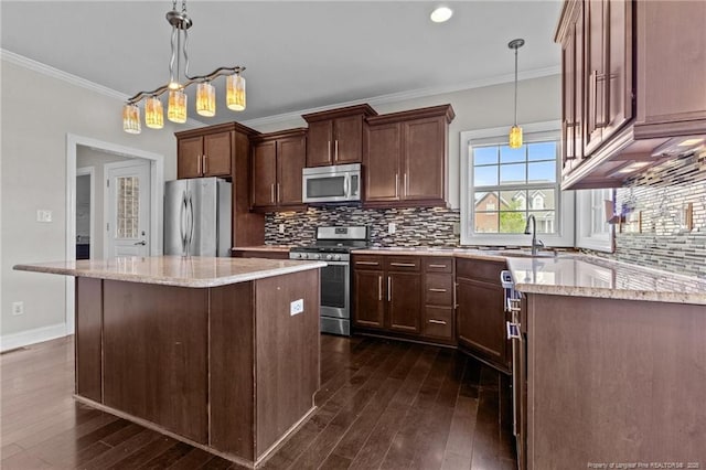 kitchen with stainless steel appliances, dark wood-style flooring, ornamental molding, a center island, and light stone counters