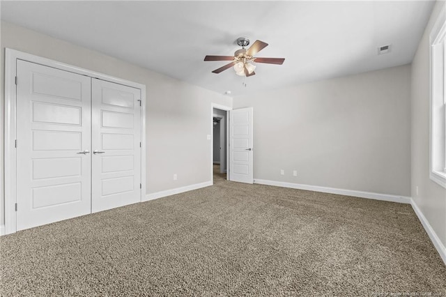 unfurnished bedroom with carpet flooring, baseboards, a closet, and ceiling fan