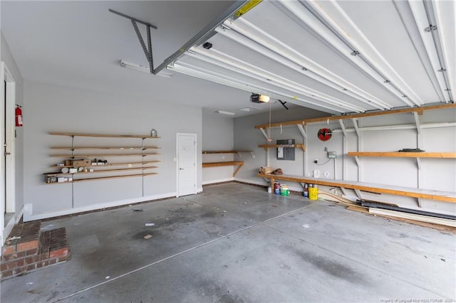garage with a workshop area, a garage door opener, and electric panel