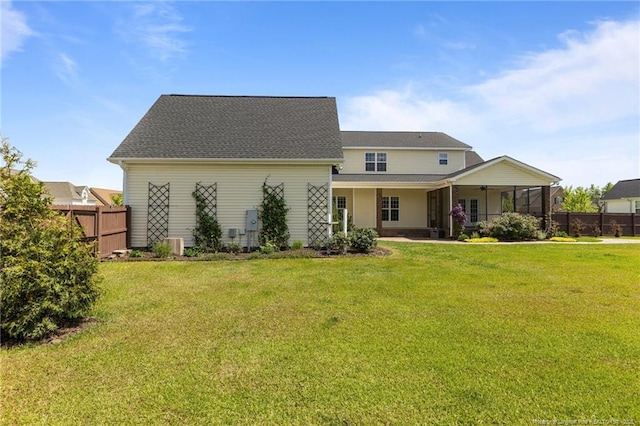 back of property with a ceiling fan and roof with shingles