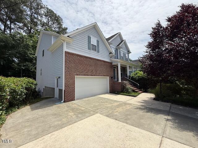 5804 Claribel Ct, Raleigh, NC 27612 - view of home's exterior featuring an attached garage, brick siding, and driveway