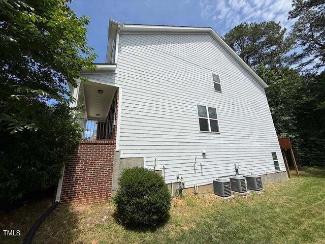 5804 Claribel Ct, Raleigh, NC 27612 - view of side of home with a lawn and central AC unit