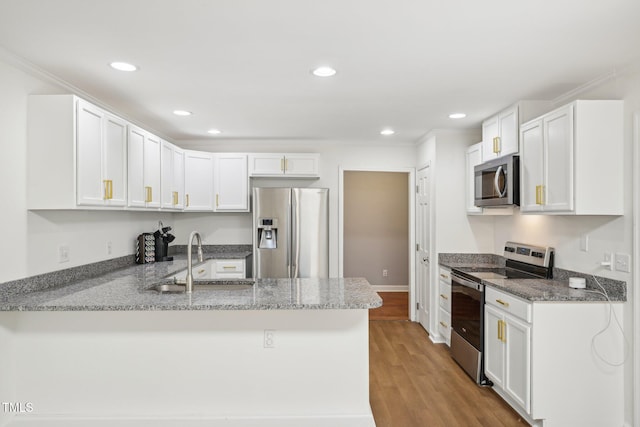 103 Lakeway Ct, Cary, NC 27511 - kitchen with appliances with stainless steel finishes, a sink, a peninsula, white cabinetry, and recessed lighting