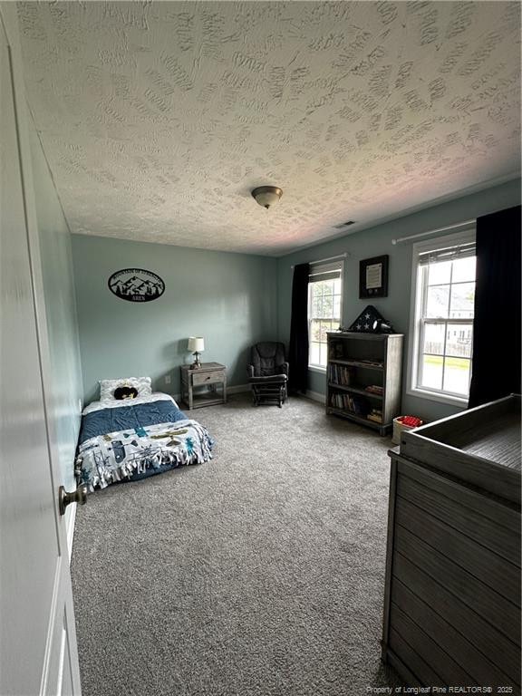 bedroom with a textured ceiling and carpet floors