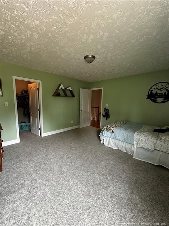 bedroom with a textured ceiling, carpet, and baseboards
