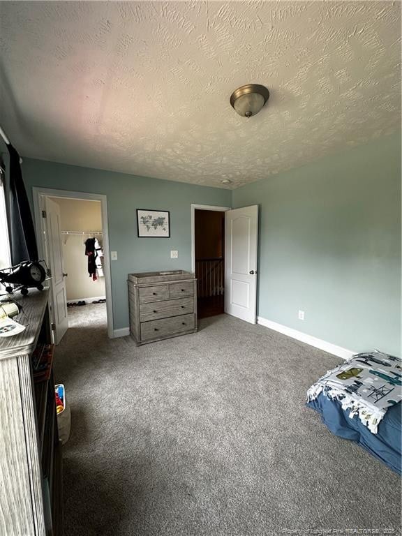 carpeted bedroom with baseboards and a textured ceiling