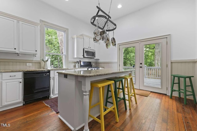 304 Linden Ave, Raleigh, NC 27601 - kitchen with dishwasher, stainless steel microwave, gas range, dark wood-type flooring, and white cabinets