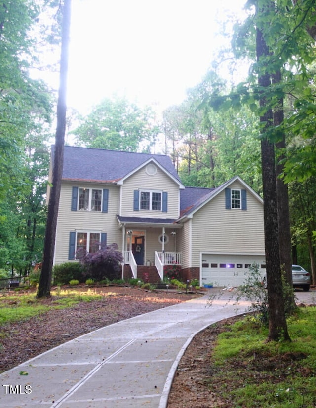 5917 Clearsprings Dr, Wake Forest, NC 27587 - traditional-style house with a porch, concrete driveway, a garage, brick siding, and view of wooded area
