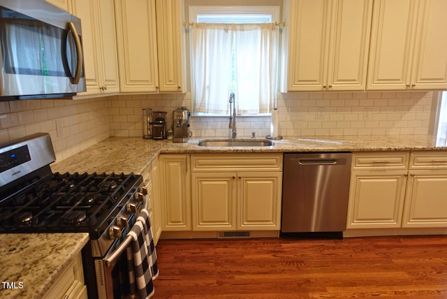 5917 Clearsprings Dr, Wake Forest, NC 27587 - kitchen with stainless steel appliances, a sink, dark wood-style flooring, and backsplash