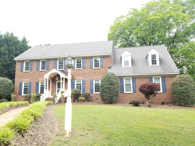 view of front of home featuring a front yard, brick siding, and crawl space