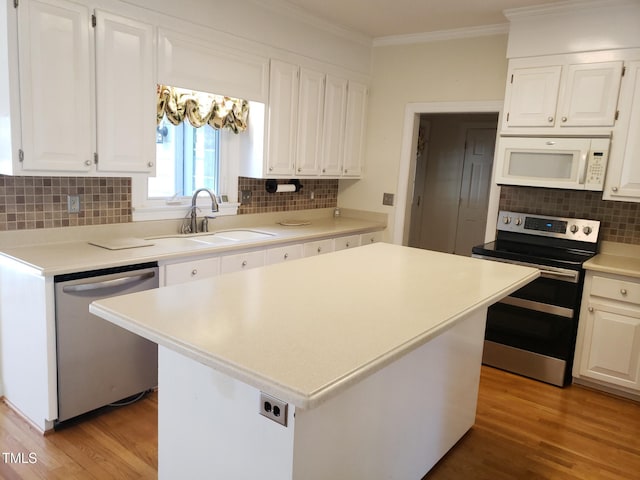 1711 Westbrook Dr NW, Wilson, NC 27896 - kitchen with appliances with stainless steel finishes, a sink, crown molding, backsplash, and white cabinetry