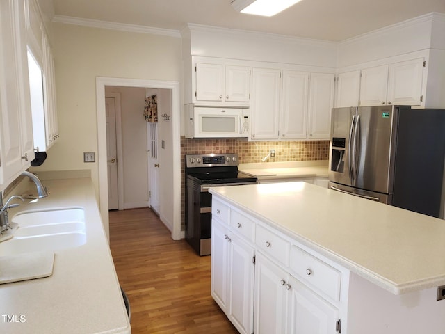 1711 Westbrook Dr NW, Wilson, NC 27896 - kitchen featuring appliances with stainless steel finishes, light wood finished floors, a sink, light countertops, and crown molding