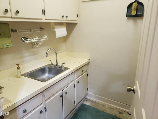 1711 Westbrook Dr NW, Wilson, NC 27896 - kitchen featuring a sink, light countertops, white cabinets, concrete floors, and baseboards