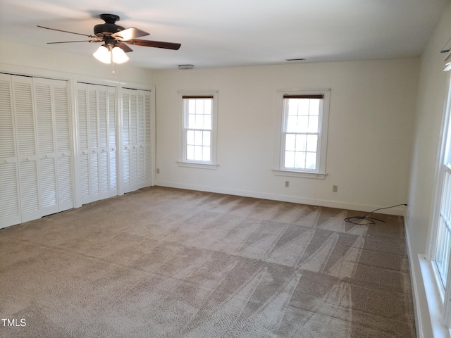 1711 Westbrook Dr NW, Wilson, NC 27896 - unfurnished bedroom featuring carpet flooring, multiple closets, baseboards, and a ceiling fan