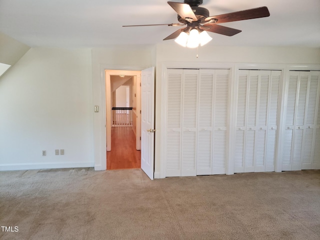1711 Westbrook Dr NW, Wilson, NC 27896 - unfurnished bedroom with carpet flooring, multiple closets, baseboards, ceiling fan, and lofted ceiling