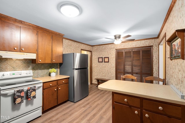 4004 Bamburgh Ln, Apex, NC 27539 - kitchen with electric range, under cabinet range hood, freestanding refrigerator, wallpapered walls, and ornamental molding