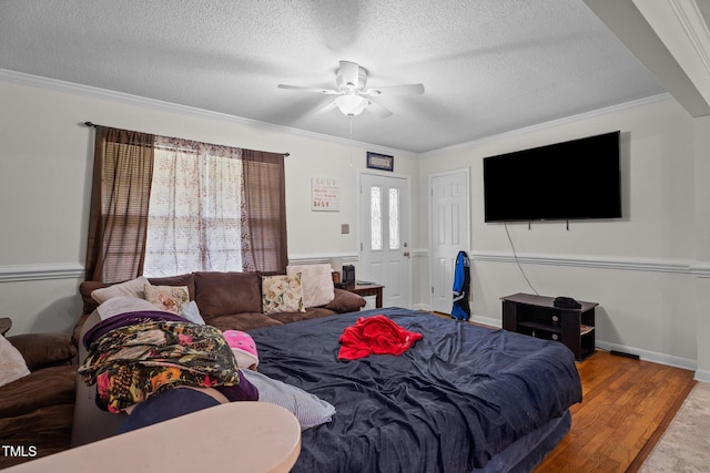 living area featuring crown molding, a ceiling fan, a textured ceiling, and wood finished floors